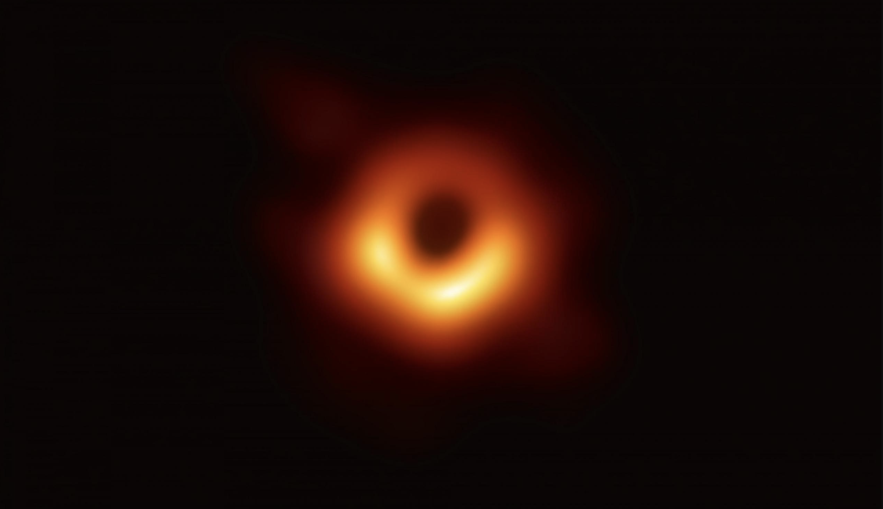 Esta imagen muestra un brillante anillo rojo formado a medida que la luz se dobla por la intensa gravedad que ejerce el agujero negro de 6.500 millones de veces la masa del Sol.